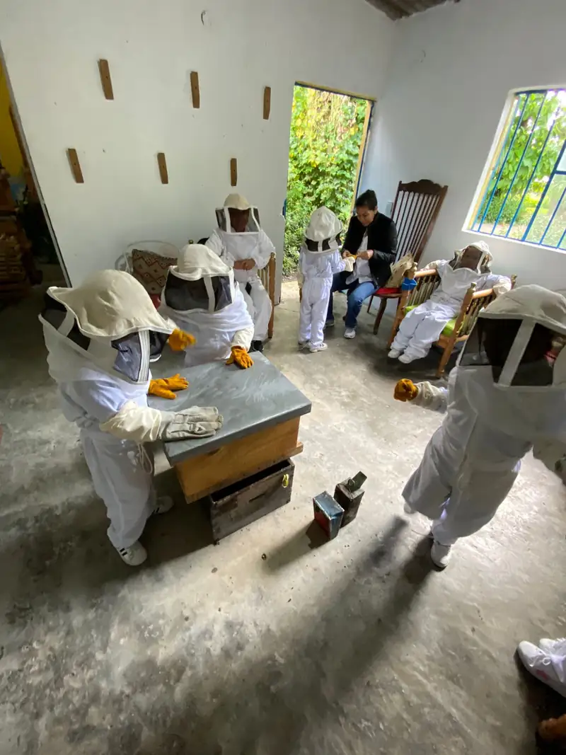 Niños con traje de apicultor en el taller